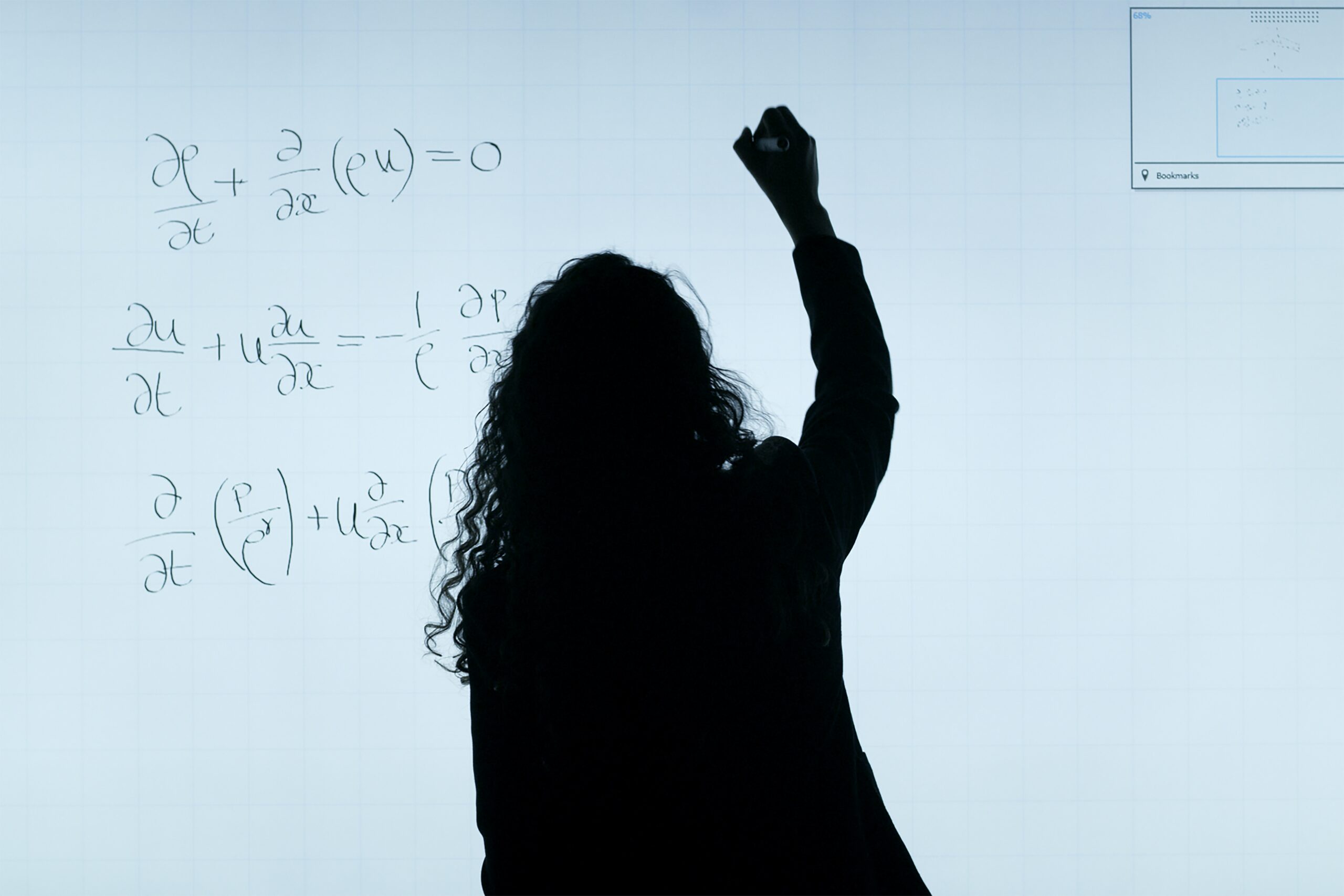 Lady in front of whiteboard writing maths equations.